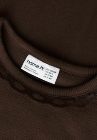 Mørkebrun ribbet stofftopp med blondestrimle nær halsen og hvit innsydd størrelsesetikett som viser størrelse EU 122/128, US 6X-7, laget i Tyrkia.