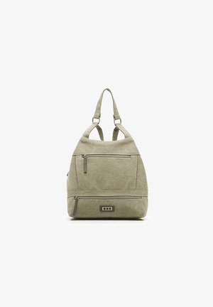 Mochila de color verde oliva claro con un tejido texturizado. Cuenta con múltiples bolsillos con cremallera y correas ajustables. Diseño minimalista con sutiles acentos de hardware.