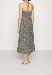 Květinové, bezrukávové maxi šaty s modrým pozadím, s nařaseným korzetem a mnohobarevnými květy. Zpětní vázací detail, lehký materiál.