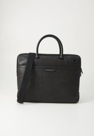 Black laptop bag made of textured synthetic material, featuring leather handles, a shoulder strap, and a front logo plaque.