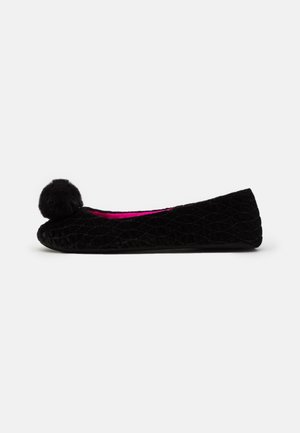 Black velvet ballet flat with a textured, quilted pattern and a fur pom-pom accent on the toe. Bright pink interior lining.