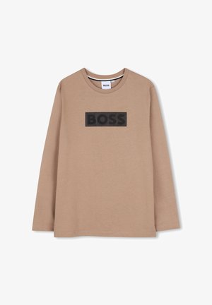 Beżowa koszulka z długim rękawem i okrągłym dekoltem z czarnym tekstem "BOSS" na środku klatki piersiowej. Prosty, casualowy design.