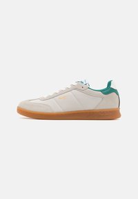 Zapatillas blancas con paneles de ante y cuero, acentos verdes en el talón y una suela de goma. Presenta cordones blancos y un logo en el lateral.