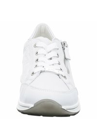 White sneaker with textured panels, lace-up front, and side zipper. Features a rounded toe and a gray rubber sole. Subtle logo detail present.