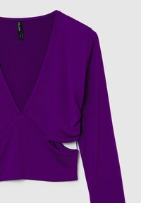Top lungo viola con maniche a  lunga e scollo a V, con dettagli arricciati in vita e ritagli laterali. Realizzato in un tessuto morbido e elasticizzato.
