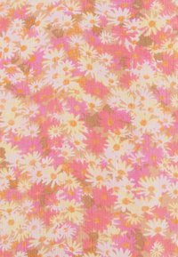 Blommigt tyg med små vita tusenskönor med gula mittpunkter på en bakgrund av rosa och persika. Texturen verkar vävd med en mjuk finish.