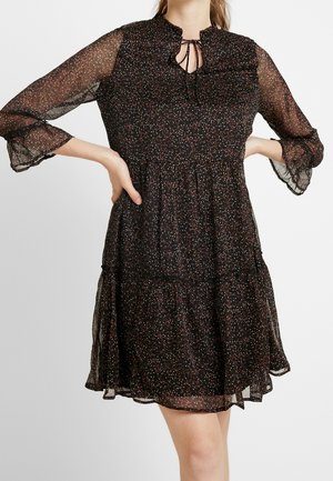 Schwarzes, semi-transparentes Kleid mit rüschigem Kragen, langen Ärmeln und einem gestuften Rock, der mit bunten, kleinen Blumenmustern verziert ist.