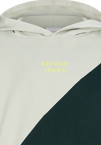 Felpa con cappuccio con blocchi di colore diagonali beige chiaro e verde scuro e testo giallo "RETOUR JEANS" sul petto.