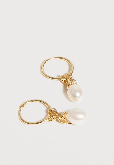 Χρυσά σκουλαρίκια κρίκοι με σχεδιασμό στριμμένου σύρματος, καθένα με ένα λευκό μαργαριταρένιο μενταγιόν σε σχήμα σταγόνας.