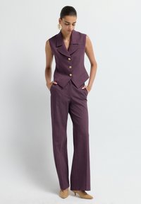 Violet tailored vest with a notched collar and three gold buttons, paired with wide-leg trousers in the same fabric. Smooth texture, formal design.
