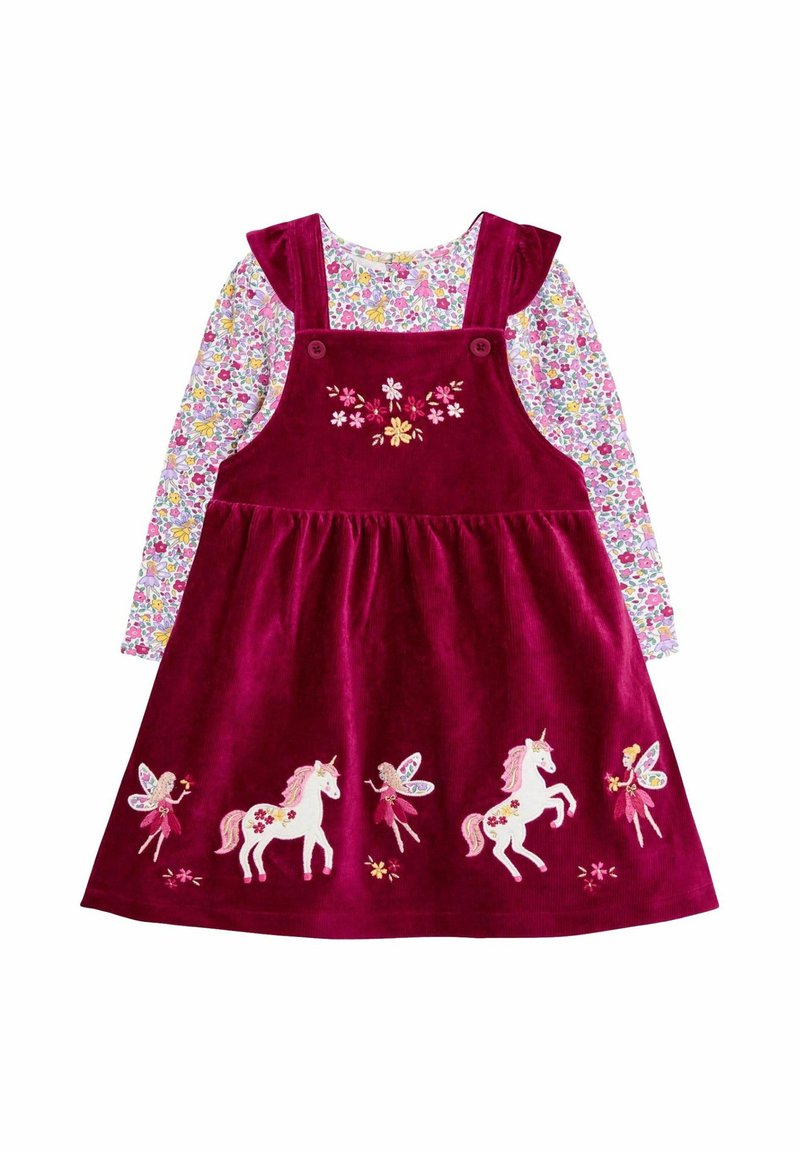 Vestido de peto de pana burdeos con unicornios y hadas bordados, llevado sobre una camisa de manga larga de flores con flores en tonos rosa, amarillo y púrpura.