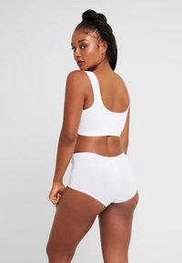 Witte katoenen bralette en set met hoogzichtbare slip. Kenmerkt zich door een gladde textuur, brede bandjes en een comfortabele pasvorm. Eenvoudig en onopgesmukt ontwerp.