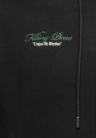 Schwarzer Hoodie mit einem Frontlogo, "Filling Pieces" in grüner Schreibschrift und dem Satz "United By Rhythm" in Weiß. Verfügt über eine Kordel und eine glatte Textur.