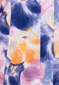 Blommönstrad tyg med stora blomblad i nyanser av blått, rosa, orange och gult; inkluderar en sydd fickdetalj.