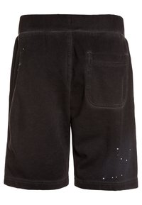 Černé bavlněné šortky s volným střihem, elastickým pasem a zadní kapsou. Výrazný detail bílých skvrn od barvy poblíž lemu.