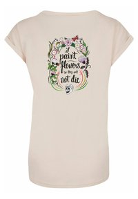 Hellrosa Kurzarm-T-Shirt mit einem dekorativen Design aus Blumen, Schmetterlingen und einem Schädel, einschließlich des Textes "Ich male Blumen, damit sie nicht sterben."