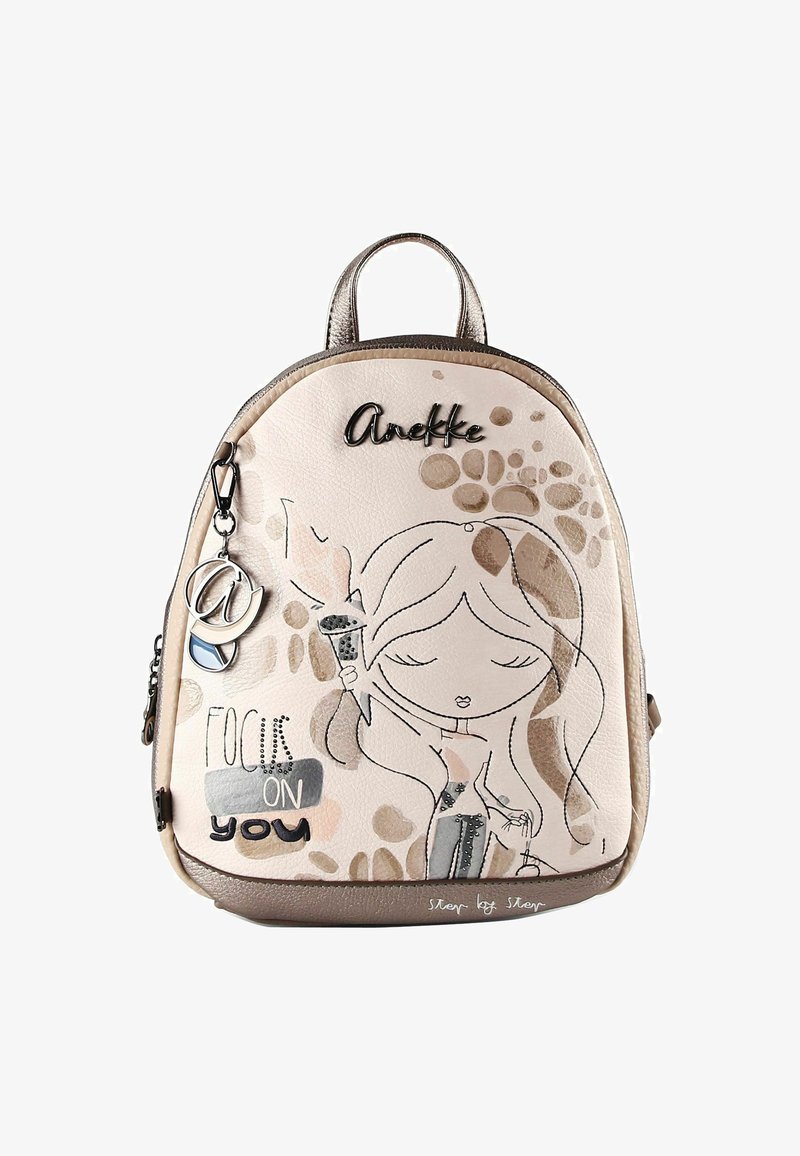 Petit sac à dos beige avec illustration d'une fille tenant une torche, texte « Focus on you » et logo ainsi que pendentif métallique « Anekke ».