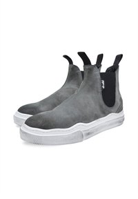 Zapatos de ante gris sin cordones con paneles laterales elásticos, suelas blancas de goma y detalles texturizados a lo largo del borde. Presentan tiradores en la parte posterior.