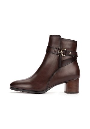 Bota de cuero marrón oscuro hasta el tobillo con tacón bloque y correa decorativa con hebilla dorada alrededor del tobillo.