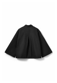 Veste noire oversize avec une coupe structurée, des manches larges et un pli au dos. Réalisée en tissu lisse et mat, avec un col.