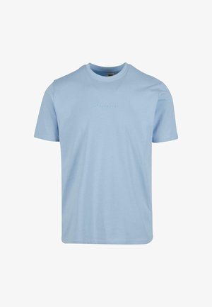 Camiseta de algodón azul claro con un cuello redondo, mangas cortas y texto en relieve en el pecho. Textura suave, ajuste casual.