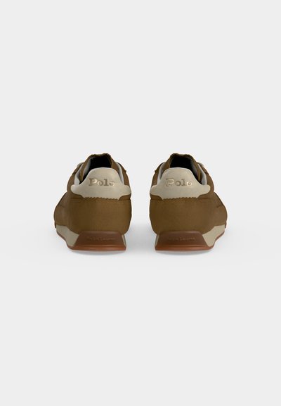Paire de baskets marron de la marque Polo vues de dos avec des languettes de talon beiges et des semelles en caoutchouc marron sur un fond uni.