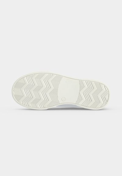 Semelle de chaussure blanche avec un motif en zigzag et une section rectangulaire lisse au centre, vue de dessous sur un fond uni.