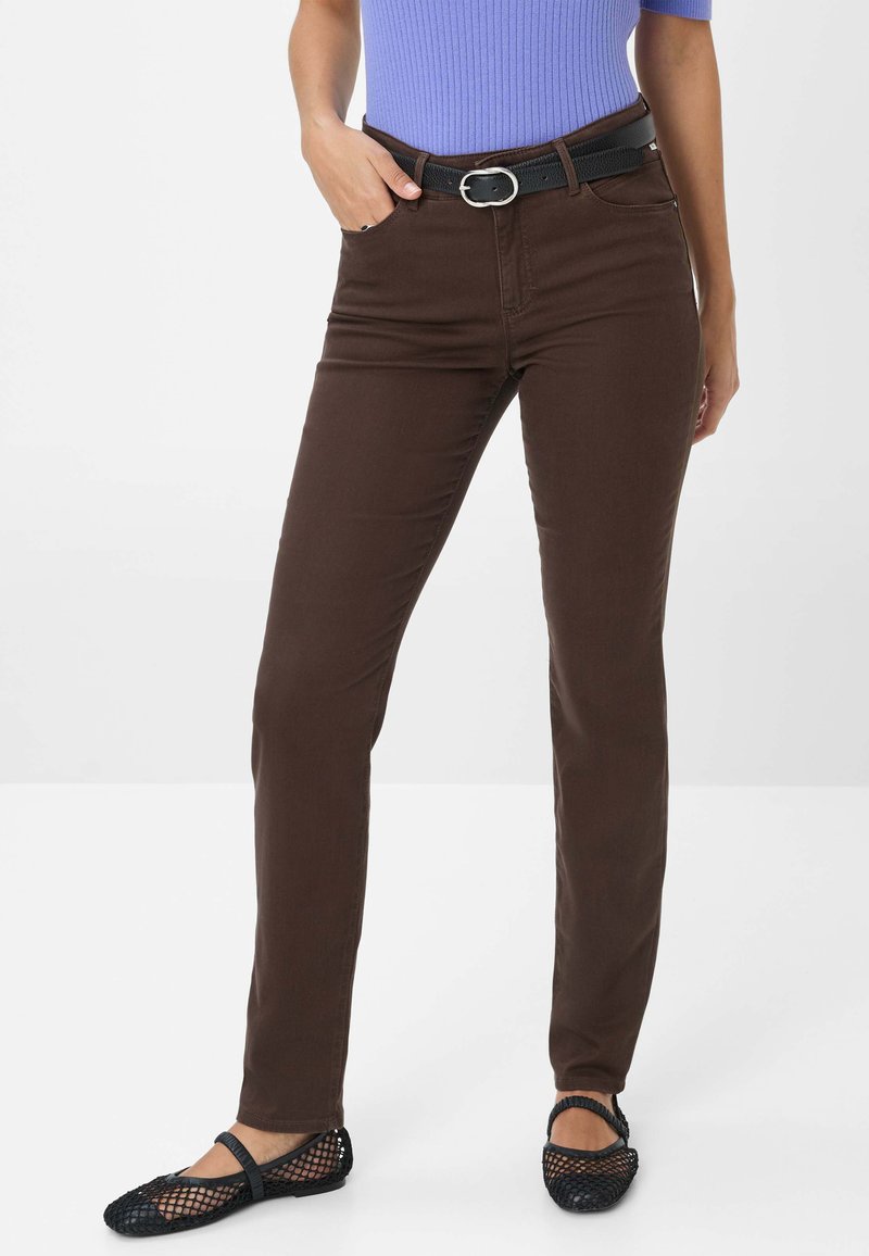 Jeans bruns ajustés avec une texture lisse, dotés d'un design classique à cinq poches et d'une ceinture noire avec une boucle en métal argenté.