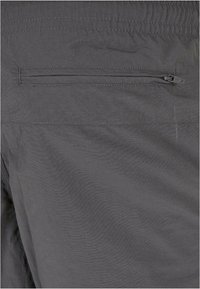 Hallid kergekaalulised lühikesed püksid, millel on sile tekstuur, seljal lukuga tasku ja elastne vöökand. Minimalistlik disain.