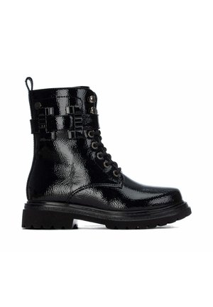 Bota de combate negra de charol brillante con cordones, suela robusta y tira decorativa con tachuelas alrededor del tobillo.