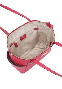 Sac à main en cuir rouge avec fermeture éclair, poches intérieures latérales, et doublure en tissu beige arborant un motif de logo de marque. Bandoulière réglable.
