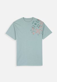 T-shirt en coton bleu clair à manches courtes avec un imprimé floral rose et vert foncé, concentré sur le côté supérieur gauche.