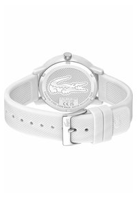 Montre en silicone blanche avec un bracelet texturé, boucle en acier inoxydable et un dos comportant un logo et des détails sur la résistance à l'eau.