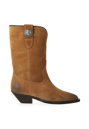 Botte de cow-boy en daim couleur fauve mi-mollet avec un bout pointu, un talon noir incliné bas et un bouton décoratif argenté sur la sangle de traction.