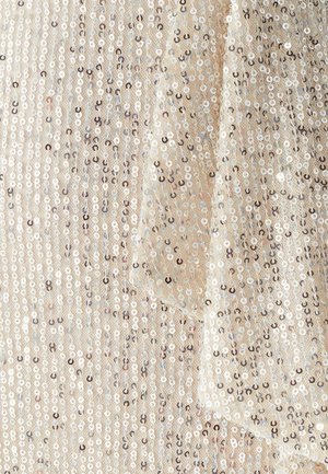 Tela de lentejuelas brillante en beige, con lentejuelas circulares blancas y plateadas alternadas dispuestas en líneas verticales, creando una superficie texturizada.