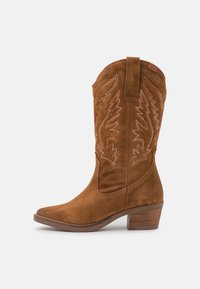 Brązowe zamszowe kowbojki z szpiczastym noskiem, ozdobnym haftem i blokowym obcasem. Posiadają pętelkę do łatwego zakładania.
