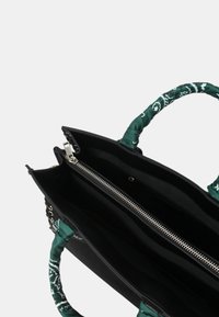 Borsa nera con manici in tessuto verde a motivo, dotata di chiusura con zip, molteplici scomparti interni e un design elegante e strutturato.