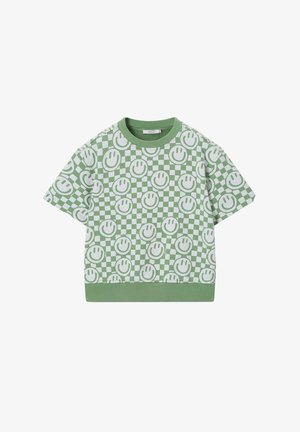 Chemise verte à manches courtes avec motif damier blanc et visages souriants verts répétés, col rond côtelé et ourlet.