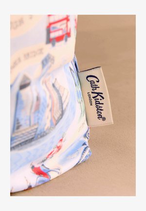 Mėlynas audinio pirkinių maišelis su Londono tema, kuriame pavaizduoti raudoni dviejų aukštų autobusai ir gėlių akcentai. Šone matoma „Cath Kidston“ etiketė.