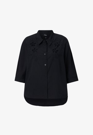 Camisa negra con botones, mangas tres cuartos, cuello y sutil bordado floral en el pecho, mostrada sobre fondo blanco.