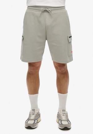 Shorts cargo gris clair en matériau doux, comportant deux poches latérales, une taille avec cordon de serrage et un petit logo en rouge.