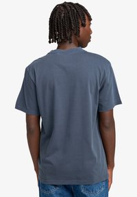 Grå bomullströja med korta ärmar, rund hals och en avslappnad passform. Tyget har en mjuk yta och minimala sömdetaljer.