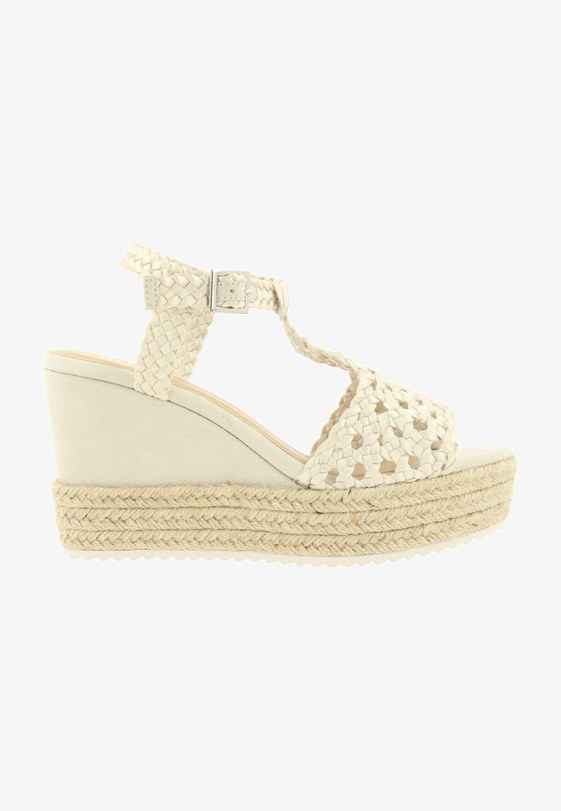 Tkané béžové espadrilky na klínovém podpatku s nastavitelným páskem kolem kotníku, strukturovaným svrškem a juty. Uzavřená špička s hladkým povrchem.