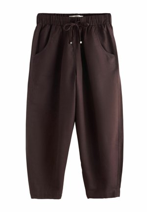 Hnědé kalhoty volného střihu s elastickým pasem, přední stahovací šňůrkou a dvěma bočními kapsami.