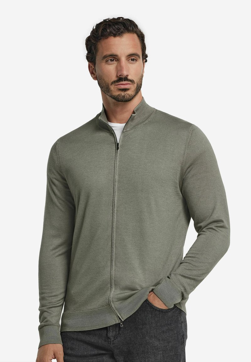 Ljusgrön zip-up jacka gjord av stickat material. Har hög krage och långa ärmar, med ribbade muddar och rak nederkant.