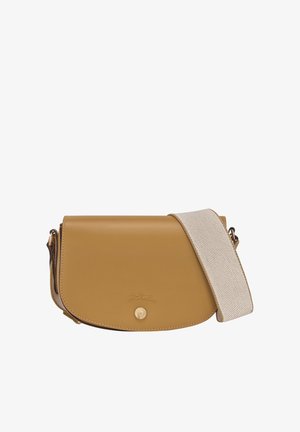 Taschen in Tan mit abgerundetem Deckel, ausgestattet mit einem strukturierten Canvas-Tragegurt und einem Logodetail auf der Vorderseite.