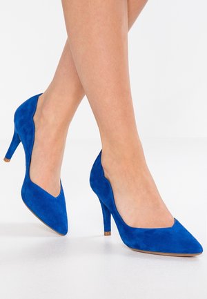 Blauwe suede hoge hakken met een spitse neus en een slanke hak van 10 cm. Glad oppervlak en een elegante uitstraling met een V-vormige uitsparing aan de bovenkant.