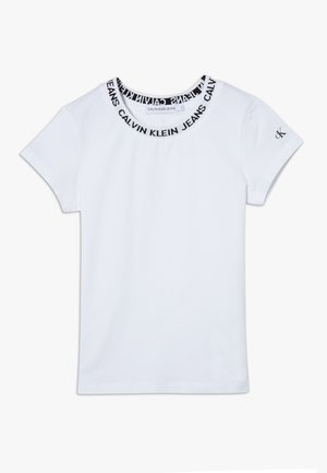 Camiseta blanca de manga corta con texto negro "Calvin Klein Jeans" alrededor del cuello y pequeño logo "ck" en la manga izquierda.