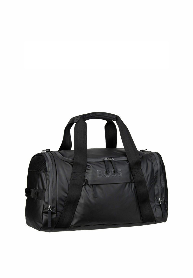 Black duffel bag made of sleek nylon with dual handles, a front zip pocket, and subtle branding. Features textured accents and sturdy straps.
