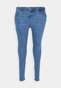 Jeans skinny em denim azul médio, com uma cintura de altura média, cinco bolsos e uma textura suave, ligeiramente desgastada.